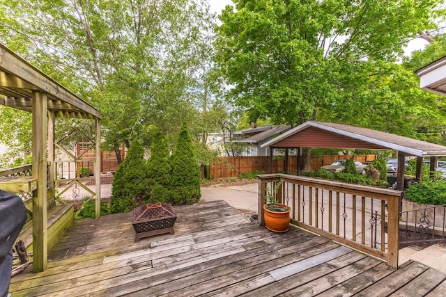 wooden deck with an outdoor fire pit and a fenced backyard