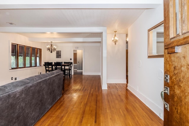 living area with a chandelier, wood finished floors, and baseboards