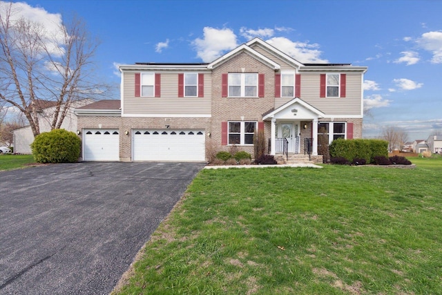229 Stone Hollow Dr, Poplar Grove, IL 61065 - traditional-style house with a front lawn, driveway, brick siding, and solar panels