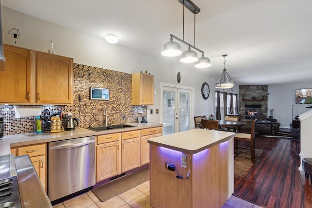 229 Stone Hollow Dr, Poplar Grove, IL 61065 - kitchen featuring stainless steel dishwasher, a sink, decorative backsplash, light countertops, and a kitchen island