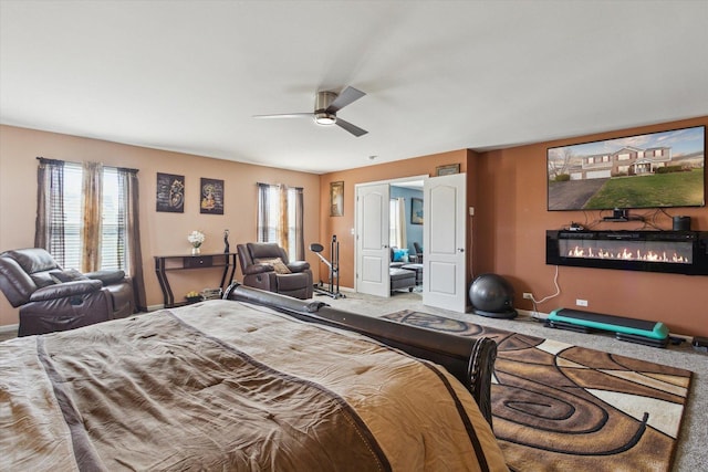 229 Stone Hollow Dr, Poplar Grove, IL 61065 - carpeted bedroom featuring a glass covered fireplace, baseboards, and ceiling fan