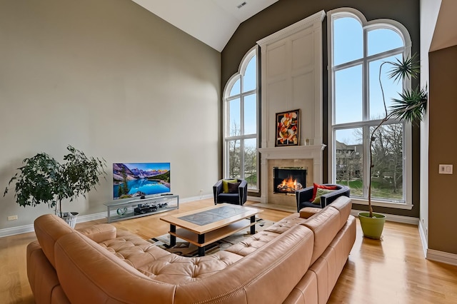 909 Prairie Ridge Ct, Burr Ridge, IL 60527 - living area with light wood-style flooring, a tiled fireplace, baseboards, and high vaulted ceiling