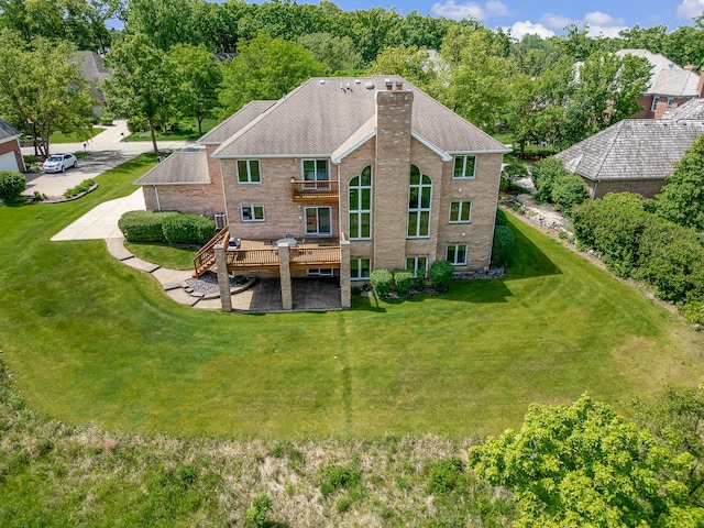 909 Prairie Ridge Ct, Burr Ridge, IL 60527 - rear view of house featuring a chimney, a deck, brick siding, and a lawn