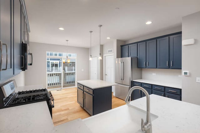 kitchen featuring appliances with stainless steel finishes, light wood-style floors, hanging light fixtures, recessed lighting, and a kitchen island