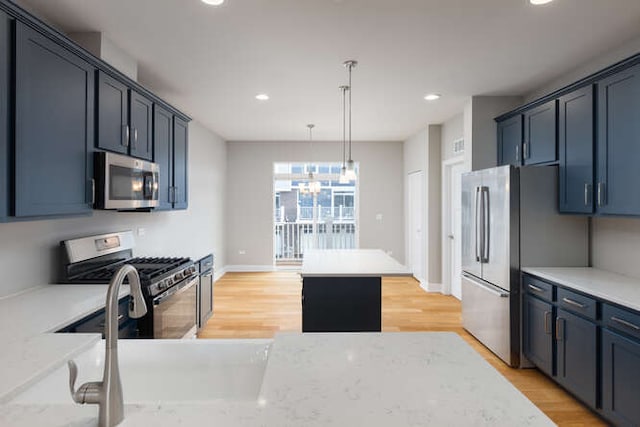 kitchen featuring appliances with stainless steel finishes, light wood-style floors, recessed lighting, a chandelier, and hanging light fixtures