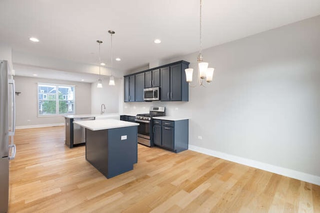 kitchen featuring appliances with stainless steel finishes, a peninsula, light countertops, light wood-style flooring, and recessed lighting