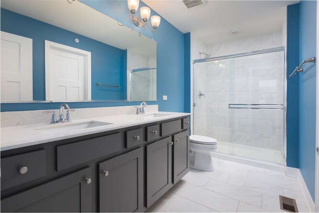 bathroom featuring a shower stall, double vanity, marble look tile flooring, toilet, and baseboards