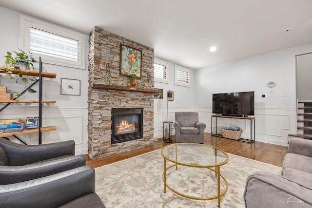 living room with stairs, a wainscoted wall, wood finished floors, and a fireplace