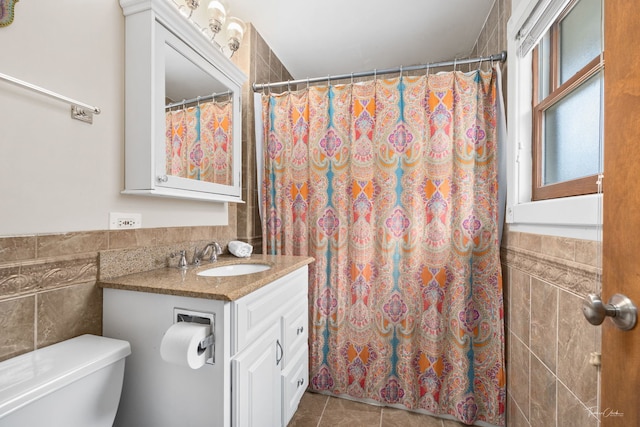 full bathroom featuring tile patterned flooring, a shower with curtain, tile walls, toilet, and vanity
