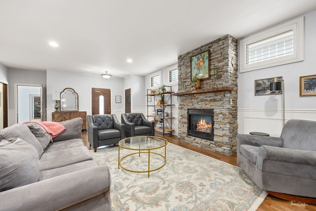 living room featuring recessed lighting, a wainscoted wall, wood finished floors, and a fireplace