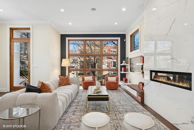 living area with plenty of natural light, ornamental molding, wood finished floors, and recessed lighting