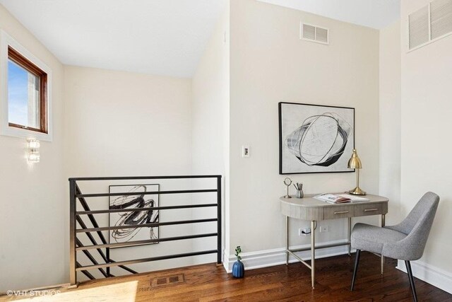 office space with baseboards, wood finished floors, and visible vents