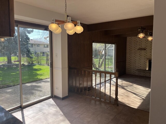 9609 S Kenneth Ave, Oak Lawn, IL 60453 - unfurnished dining area with an inviting chandelier, wood walls, tile patterned floors, and a fireplace