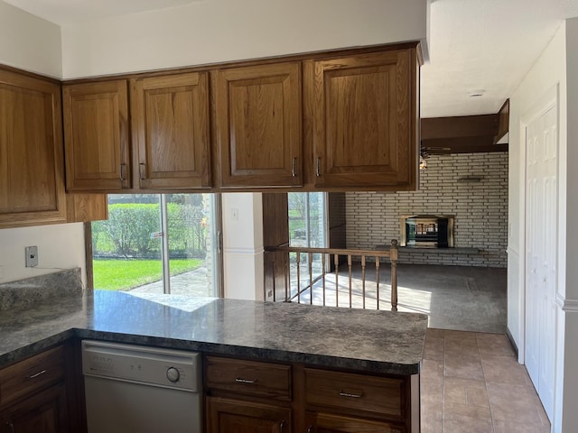 9609 S Kenneth Ave, Oak Lawn, IL 60453 - kitchen featuring white dishwasher, dark countertops, a brick fireplace, brown cabinetry, and a peninsula