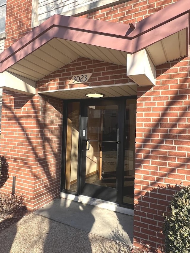 view of exterior entry with brick siding