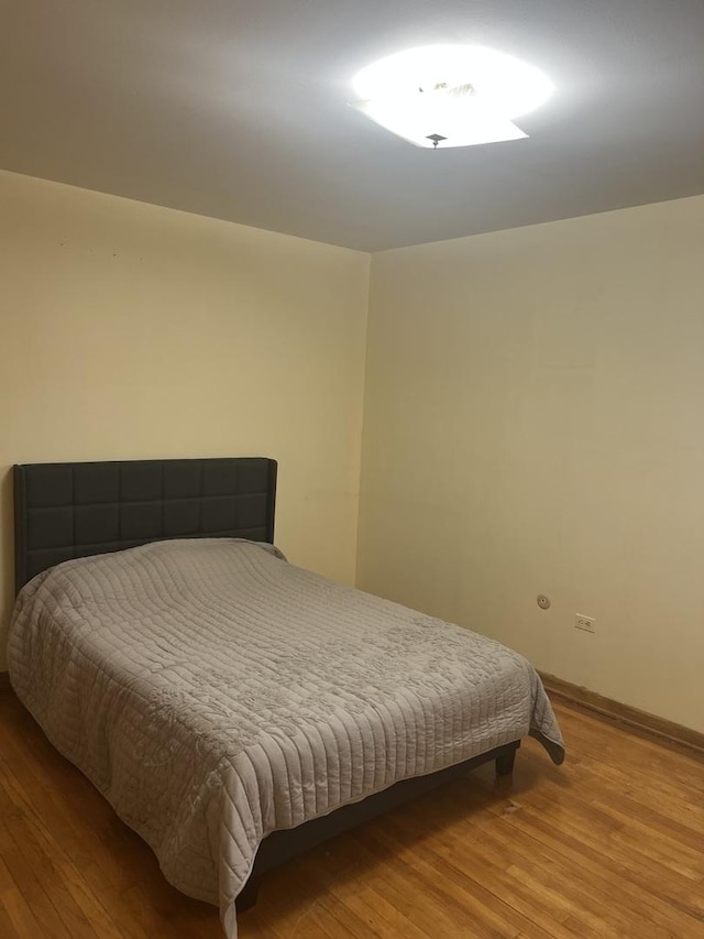 bedroom featuring wood finished floors and baseboards