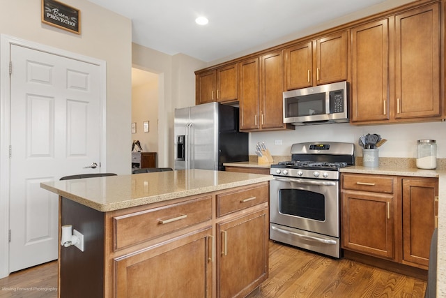 kitchen with brown cabinetry, dark wood-type flooring, and appliances with stainless steel finishes