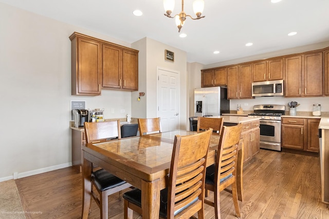 kitchen with dark wood finished floors, brown cabinets, stainless steel appliances, and light countertops