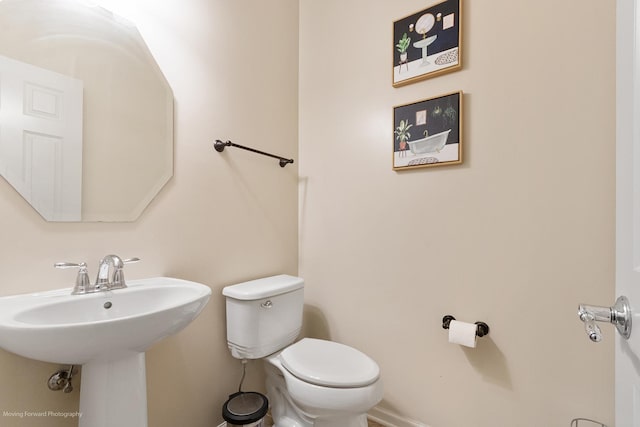 half bathroom with toilet and a sink