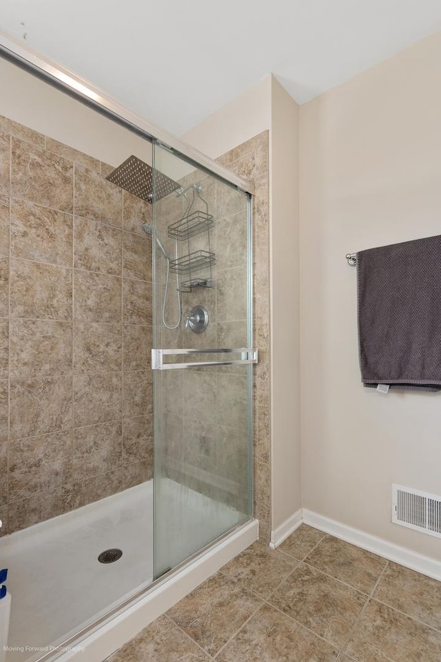 bathroom featuring a shower stall, visible vents, tile patterned floors, and baseboards