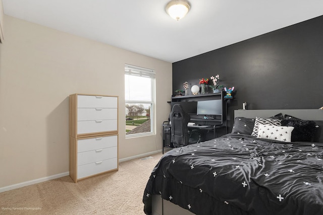 bedroom with baseboards and light colored carpet