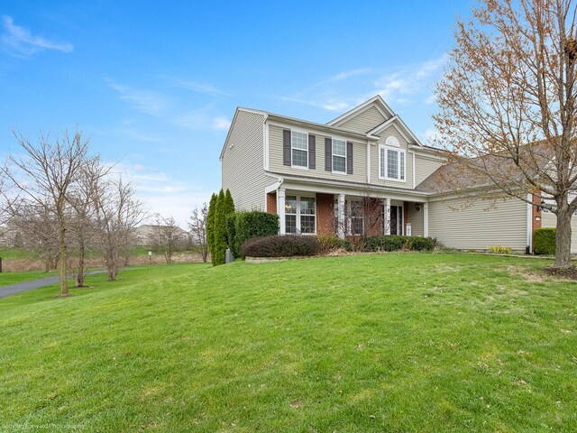 view of front of house with a front lawn, brick siding, and a porch