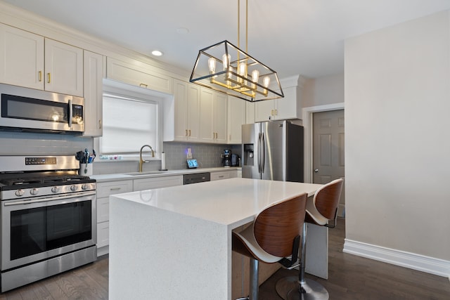 kitchen with backsplash, a sink, dark wood-type flooring, baseboards, and appliances with stainless steel finishes