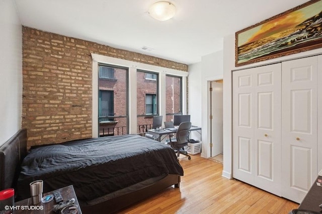 3128 W Carmen Ave Unit 2, Chicago, IL 60625 - bedroom with brick wall, light wood-style floors, and a closet