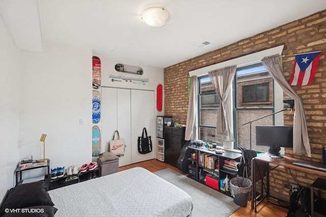 3128 W Carmen Ave Unit 2, Chicago, IL 60625 - bedroom featuring wood finished floors, a closet, and brick wall