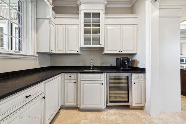 bar with built in microwave, a sink, crown molding, indoor wet bar, and beverage cooler