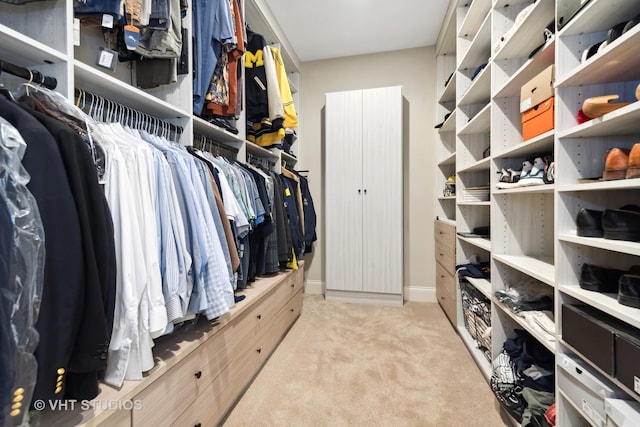 walk in closet with light carpet