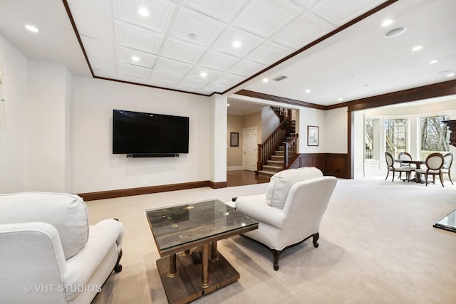 carpeted living room featuring recessed lighting, a wainscoted wall, visible vents, crown molding, and stairs