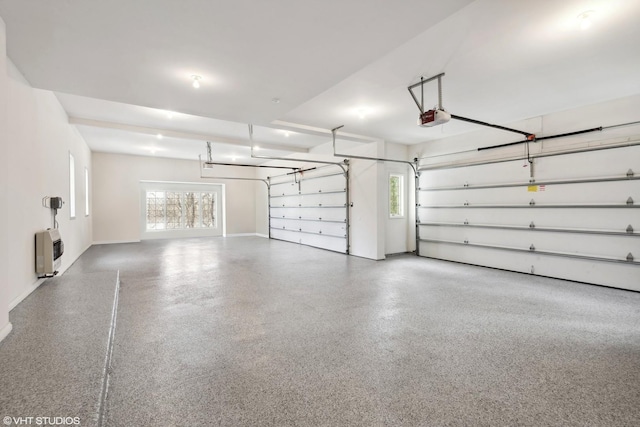 garage with a garage door opener, heating unit, and baseboards