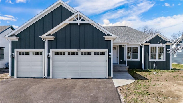 view of front of home with board and batten siding, a garage, and aphalt driveway