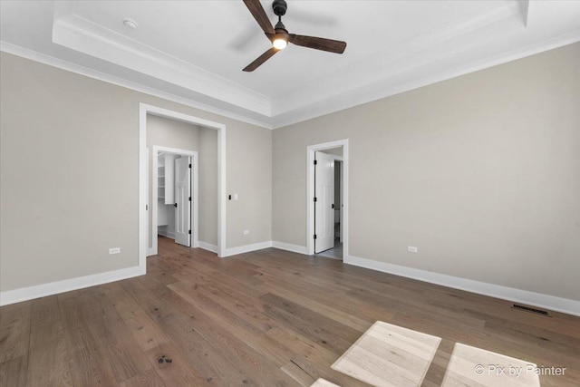 unfurnished bedroom featuring a raised ceiling, visible vents, and ornamental molding
