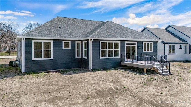 rear view of house with central air condition unit, a shingled roof, and a deck