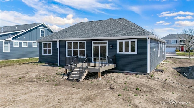 rear view of property featuring a shingled roof