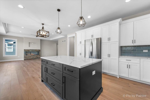 kitchen featuring recessed lighting, freestanding refrigerator, decorative backsplash, and white cabinetry
