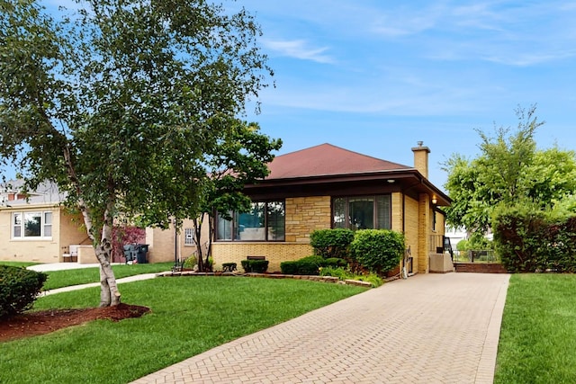 7350 N Karlov Ave, Lincolnwood, IL 60712 - view of front of property featuring decorative driveway, a chimney, a front lawn, and brick siding