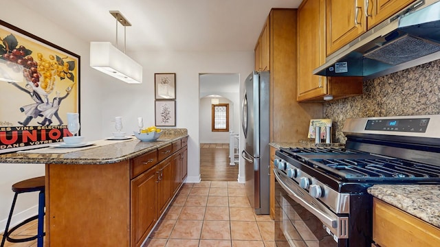 7350 N Karlov Ave, Lincolnwood, IL 60712 - kitchen featuring stainless steel appliances, under cabinet range hood, arched walkways, a peninsula, and brown cabinets
