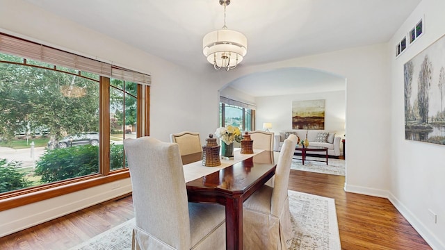 7350 N Karlov Ave, Lincolnwood, IL 60712 - dining room with arched walkways, a chandelier, and wood finished floors
