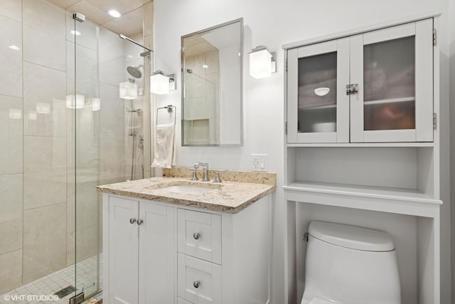 full bath featuring toilet, a shower stall, and vanity