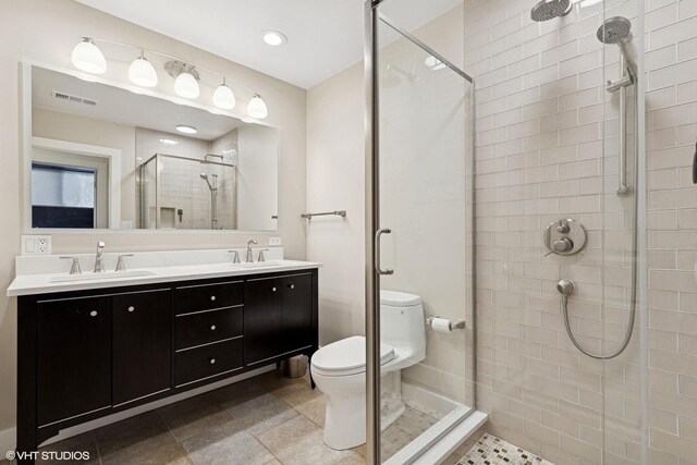 full bath with a sink, a stall shower, toilet, and double vanity