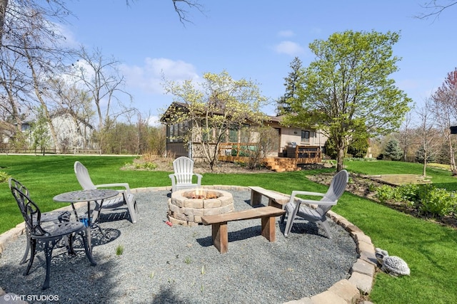 view of yard featuring a wooden deck and a fire pit