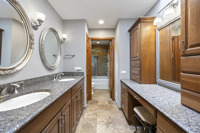 bathroom with double vanity, stone finish floor, recessed lighting, and a sink
