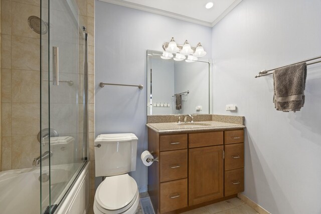 bathroom with combined bath / shower with glass door, ornamental molding, toilet, vanity, and baseboards