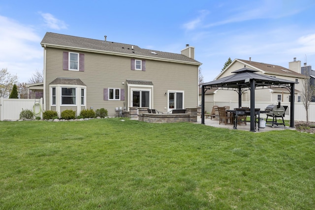 back of house with a chimney, fence, a gazebo, a patio area, and a lawn