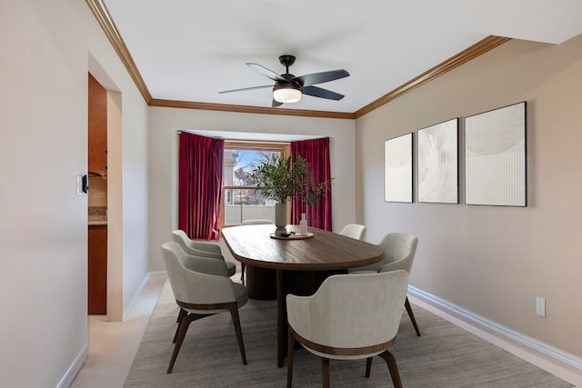 dining room featuring baseboards, ornamental molding, and ceiling fan