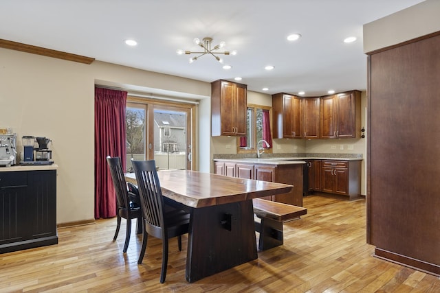 dining room featuring an inviting chandelier, recessed lighting, light wood finished floors, and baseboards