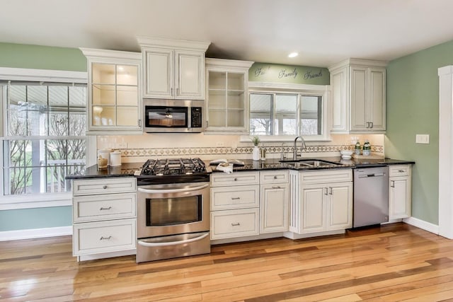 kitchen with decorative backsplash, a healthy amount of sunlight, stainless steel appliances, and a sink